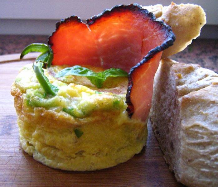 Śniadaniowy suflet jajeczny z pomidorem, zielnoną papryką i plastrem szynki.