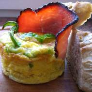 Śniadaniowy suflet jajeczny z pomidorem, zielnoną papryką i plastrem szynki.