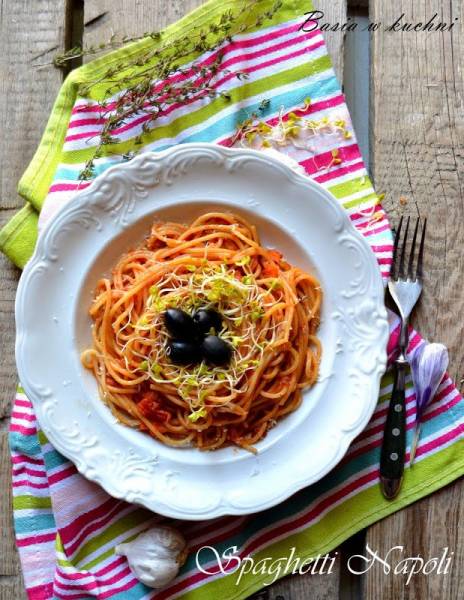 Spaghetti Napoli z czarną oliwką i kiełkami rzeżuchy.