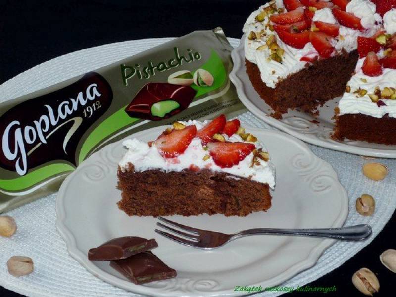 Ciasto czekoladowe z bitą śmietaną z mascarpone, truskawkami i pistacjami.