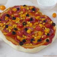 Domowa pizza z kiełbasą, pomidorkami, oliwkami i kukurydzą.