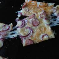 Szybka pizza z mozzarellą, kiełbasą i czerwoną cebulą.