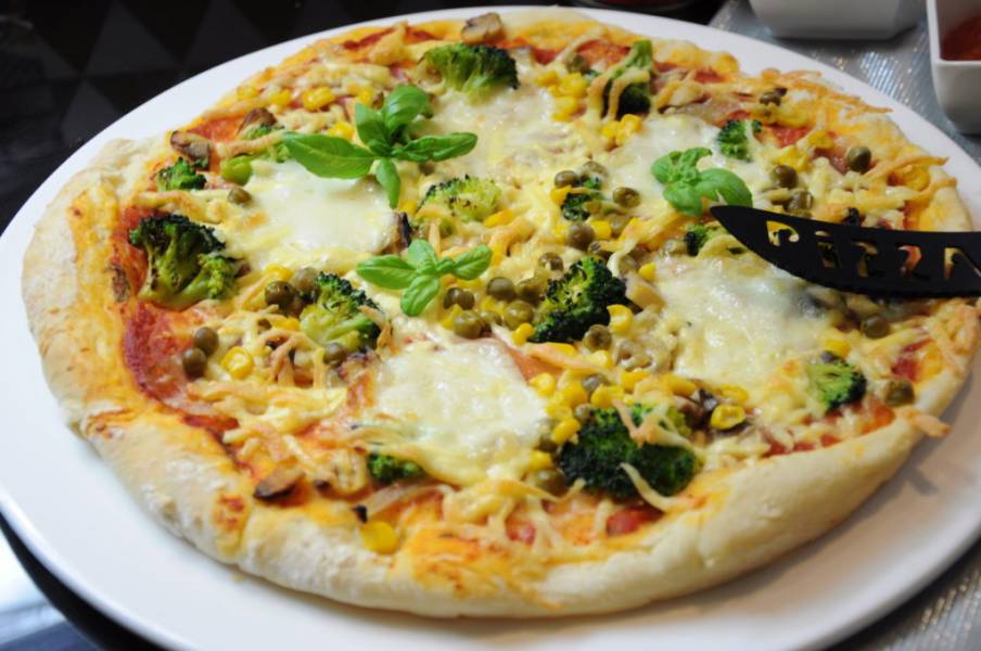 Pizza z prosciutto, brokułami, kukurydzą i groszkiem
