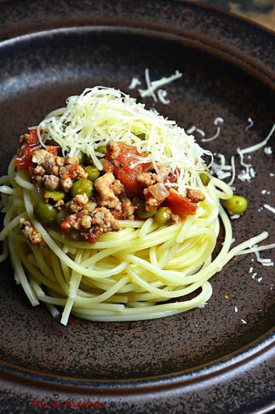 Makaron spaghetti z sosem pomidorowym, zielonym groszkiem i mieloną karkówką