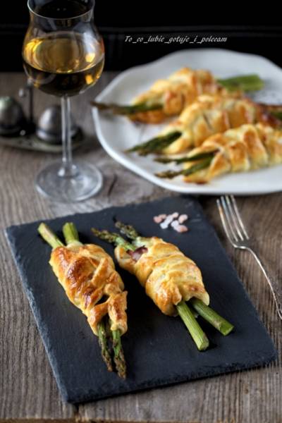 Szparagi zapiekane w cieście francuskim z szynką parmeńską i mozzarellą.
