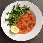 Gravlax, marynowany łosoś z kaparami i sałatą z ogórka i rukoli.