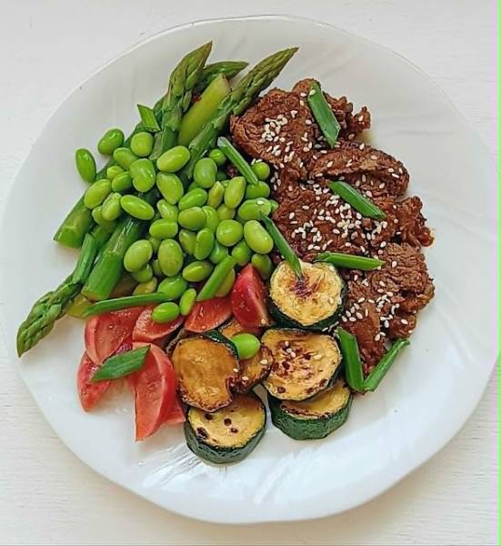 Bulgogi z polędwicy wołowej z grillowaną cukinią, zielonymi szparagami i edamame.